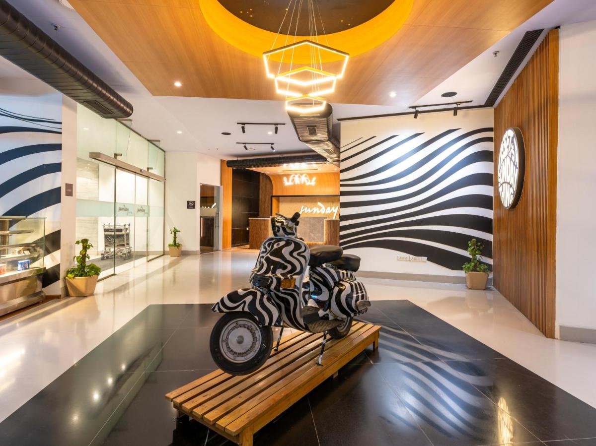 a motorcycle sculpture sitting on a bench in a lobby at Sunday Hotel Chandigarh Zirakpur in Zirakpur