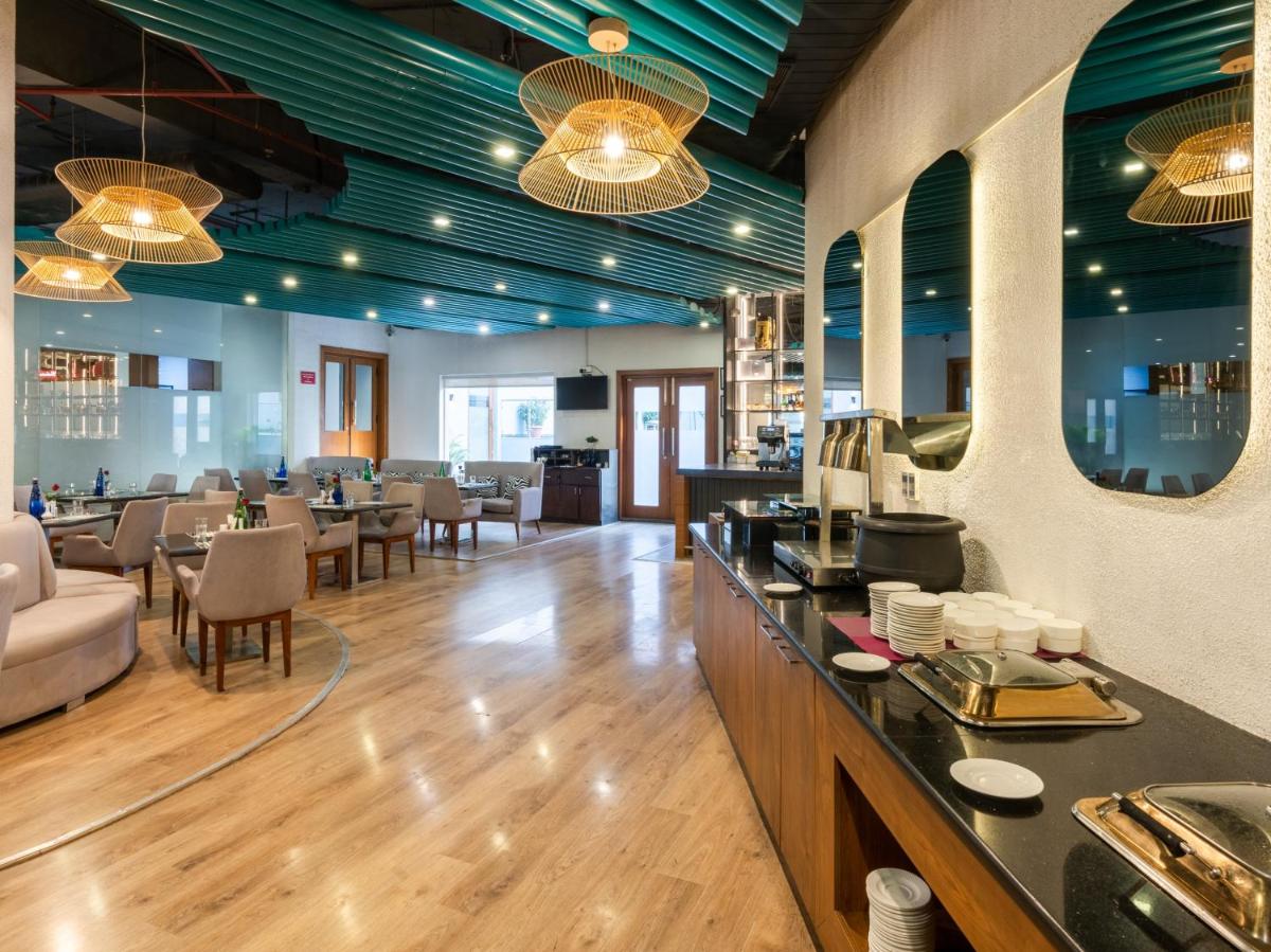 a restaurant with a bar and tables and chairs at Sunday Hotel Chandigarh Zirakpur in Zirakpur