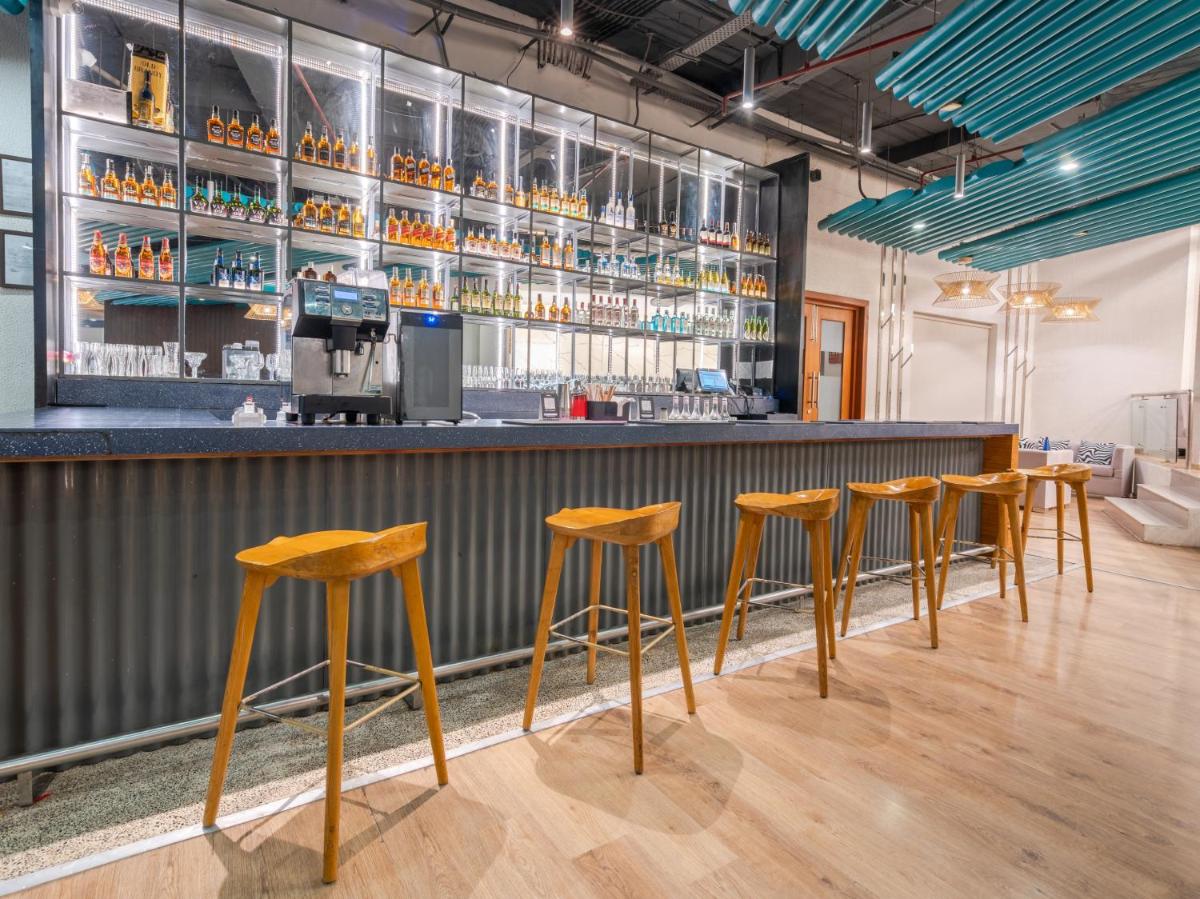 a row of stools at a bar at Sunday Hotel Chandigarh Zirakpur in Zirakpur