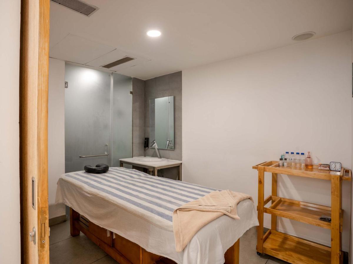 a bedroom with a bed and a sink in it at Sunday Hotel Chandigarh Zirakpur in Zirakpur