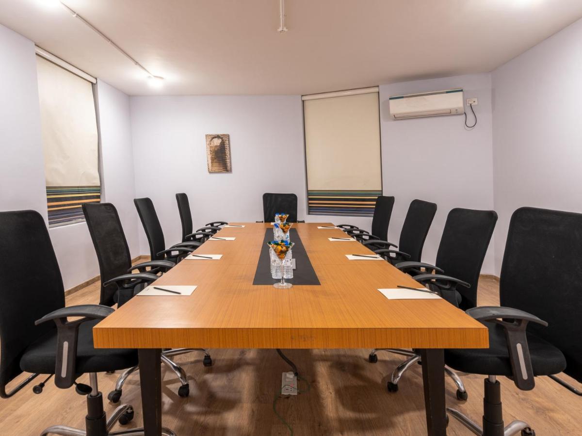a conference room with a large wooden table and chairs at Sunday Hotel Chandigarh Zirakpur in Zirakpur