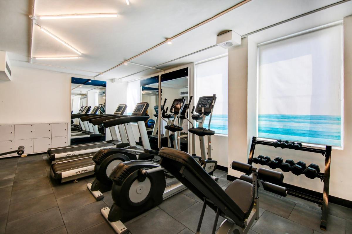 a gym with a row of treadmills and machines at Sunday Hotel Chandigarh Zirakpur in Zirakpur