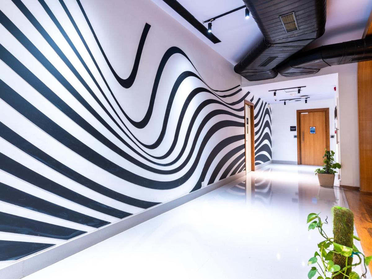 a wall mural of a hallway with blue and white stripes at Sunday Hotel Chandigarh Zirakpur in Zirakpur
