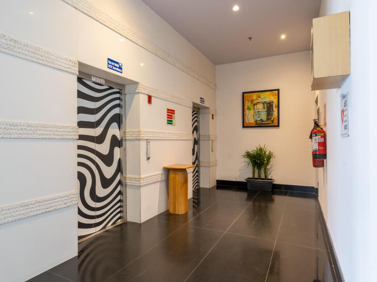 a hallway with black and white paintings on the walls at Sunday Hotel Chandigarh Zirakpur in Zirakpur