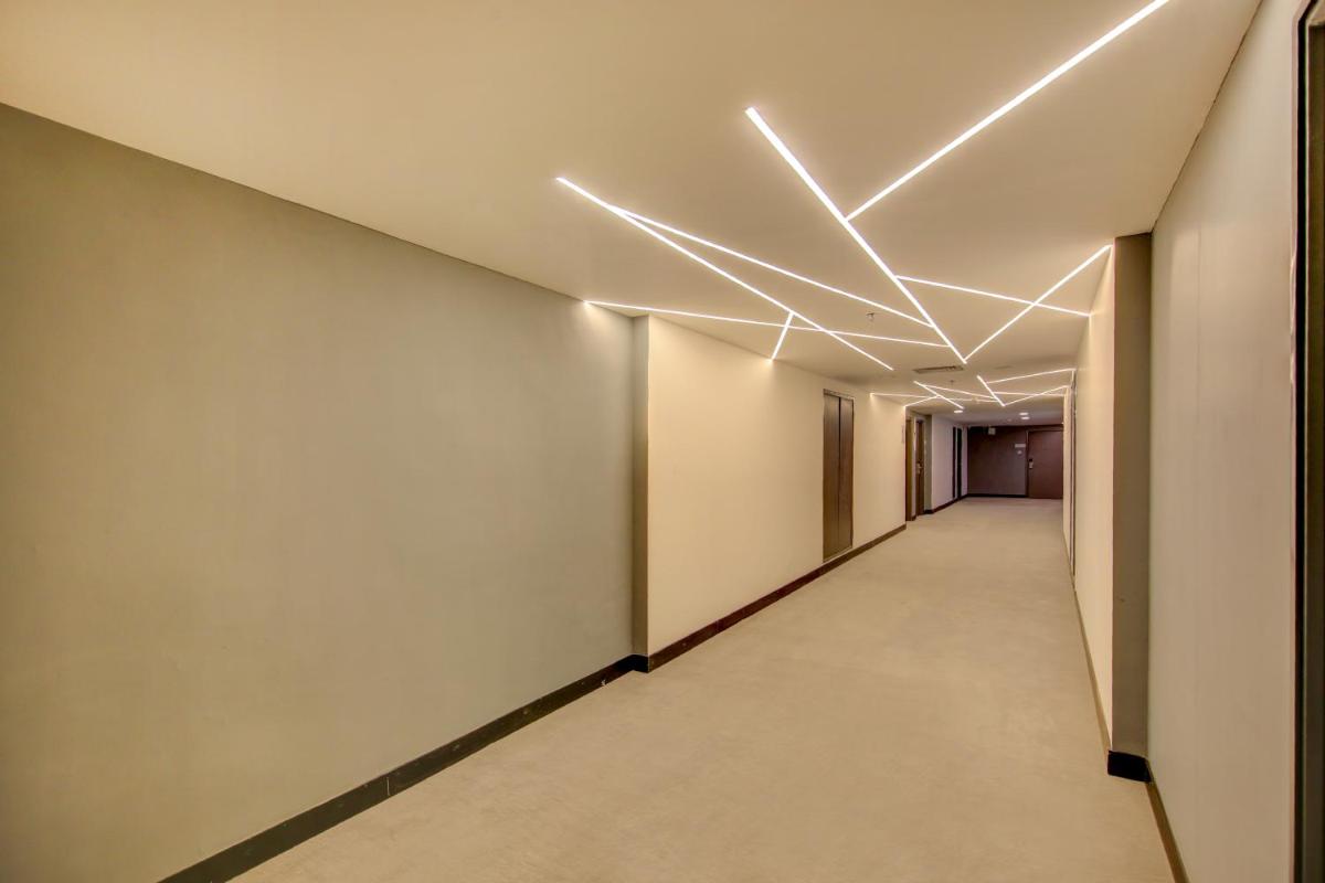a corridor of an office building with lights on the ceiling at Sunday Hotel Chandigarh Zirakpur in Zirakpur