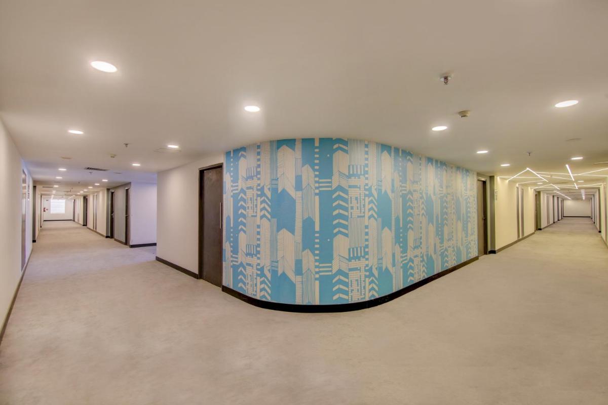 a hallway with a blue and white mural on the wall at Sunday Hotel Chandigarh Zirakpur in Zirakpur