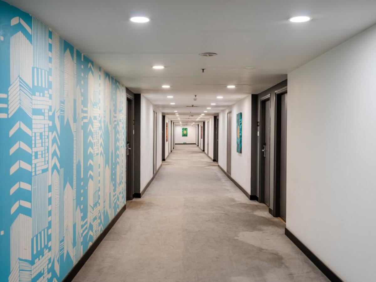 an empty corridor in an office building with blue and white walls at Sunday Hotel Chandigarh Zirakpur in Zirakpur