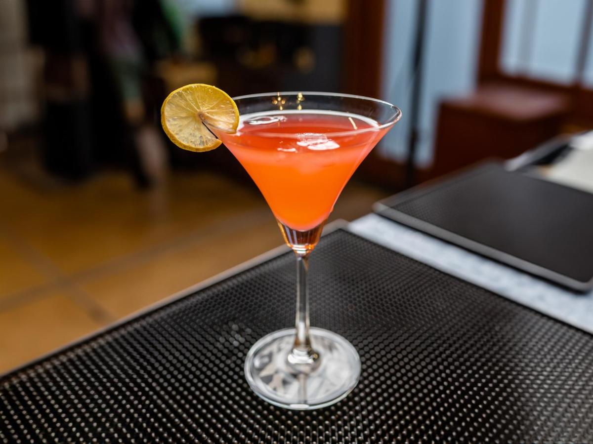 a drink in a glass with a lime on a table at Sunday Hotel Chandigarh Zirakpur in Zirakpur