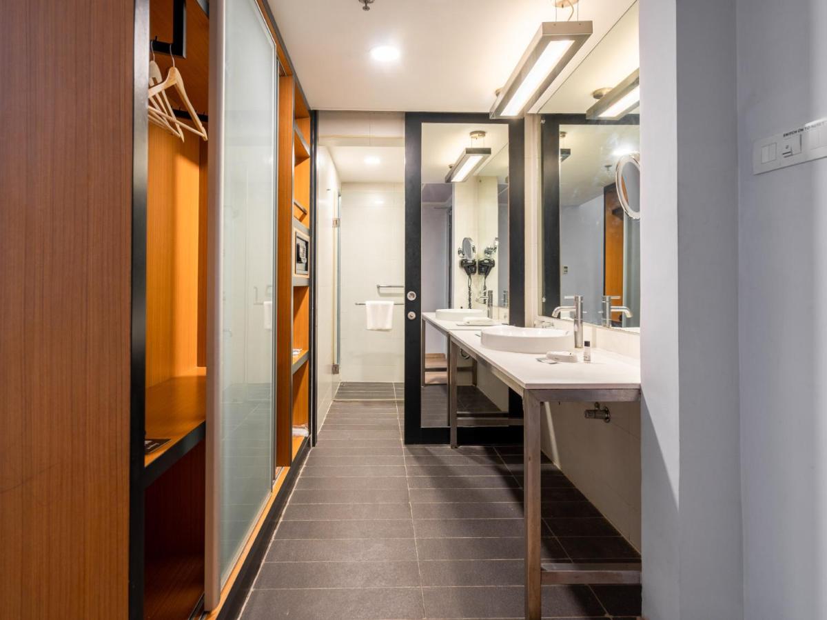 a bathroom with two sinks and two mirrors at Sunday Hotel Chandigarh Zirakpur in Zirakpur