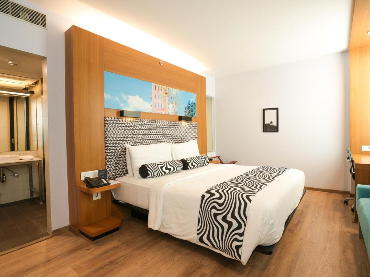 a bedroom with a bed with a zebra patterned bedspread at Sunday Hotel Chandigarh Zirakpur in Zirakpur