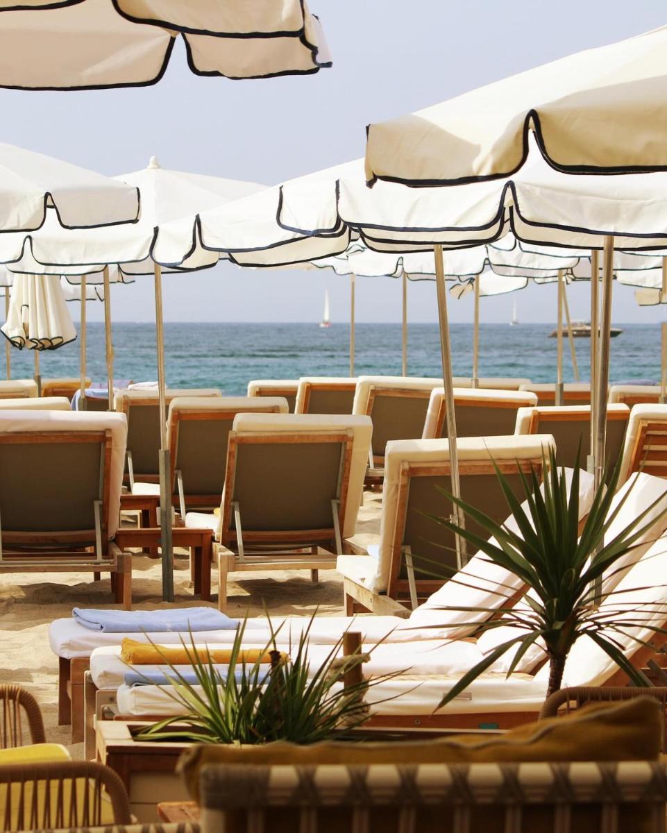 - un groupe de chaises longues et de parasols sur la plage dans l'établissement Five Seas Cannes, a Member of Design Hotels™, à Cannes