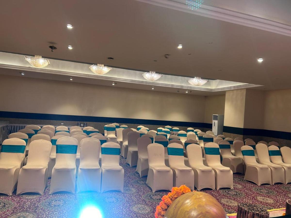 an empty room with white chairs in a room at Saura Hotel, Agra - A Club Mahindra Associate in Agra