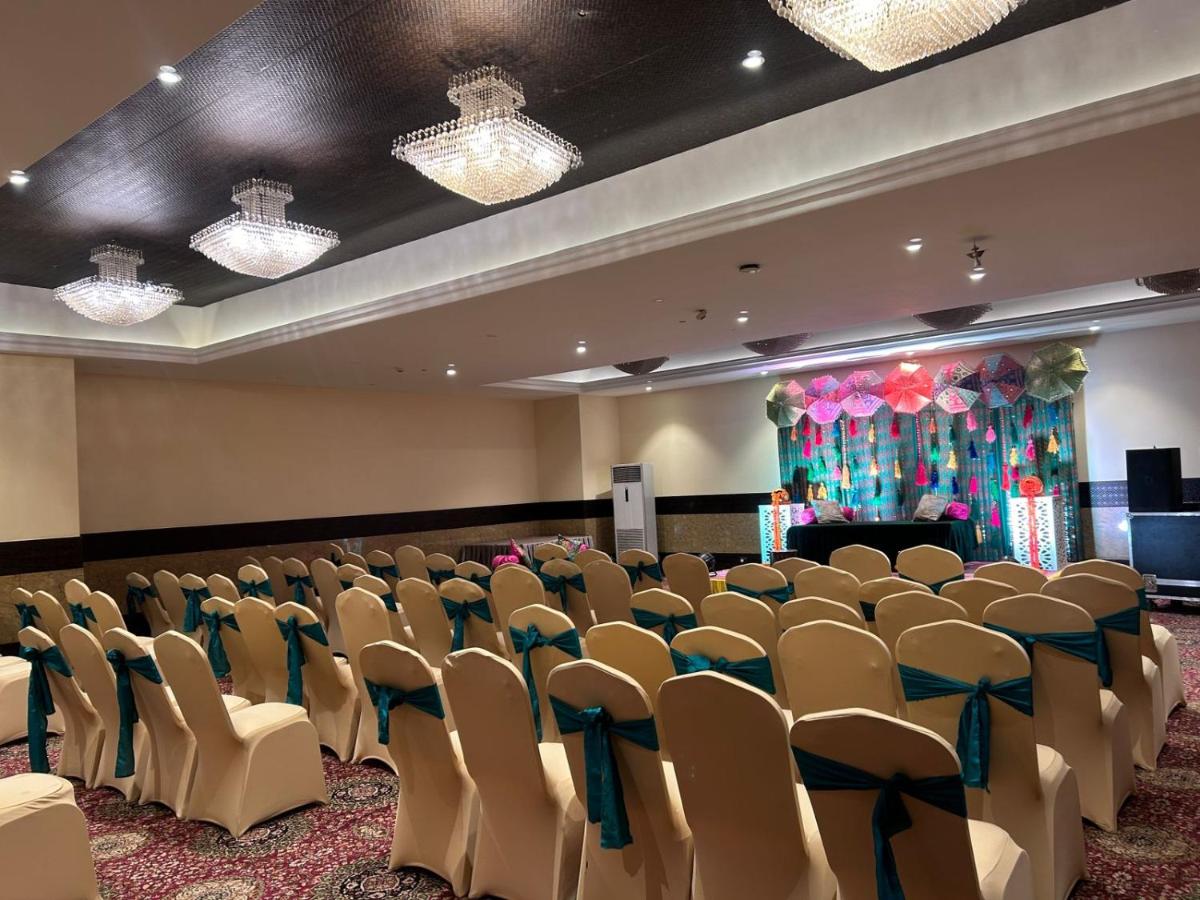 a conference room with chairs and a stage with a podium at Saura Hotel, Agra - A Club Mahindra Associate in Agra