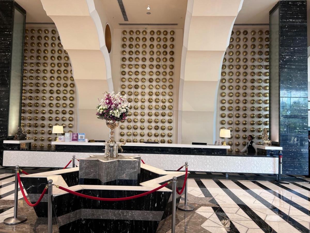 a lobby with a table with flowers on it at Saura Hotel, Agra - A Club Mahindra Associate in Agra