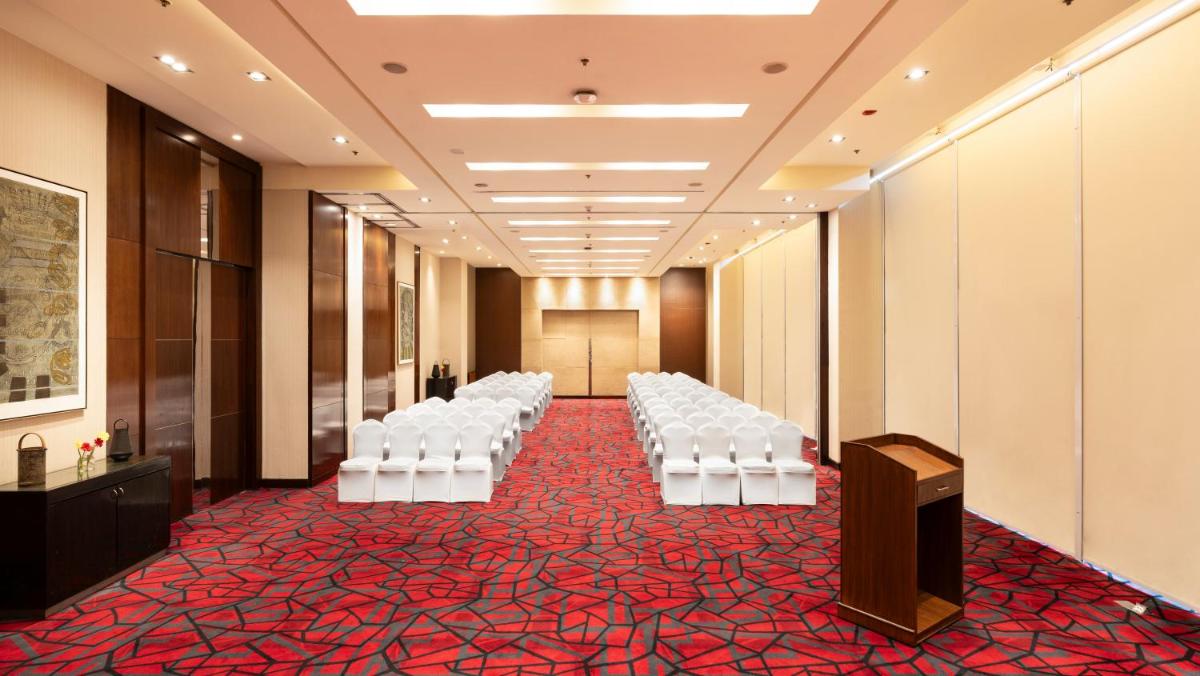 a room with rows of white chairs and a podium at Courtyard by Marriott Pune Hinjewadi in Pune