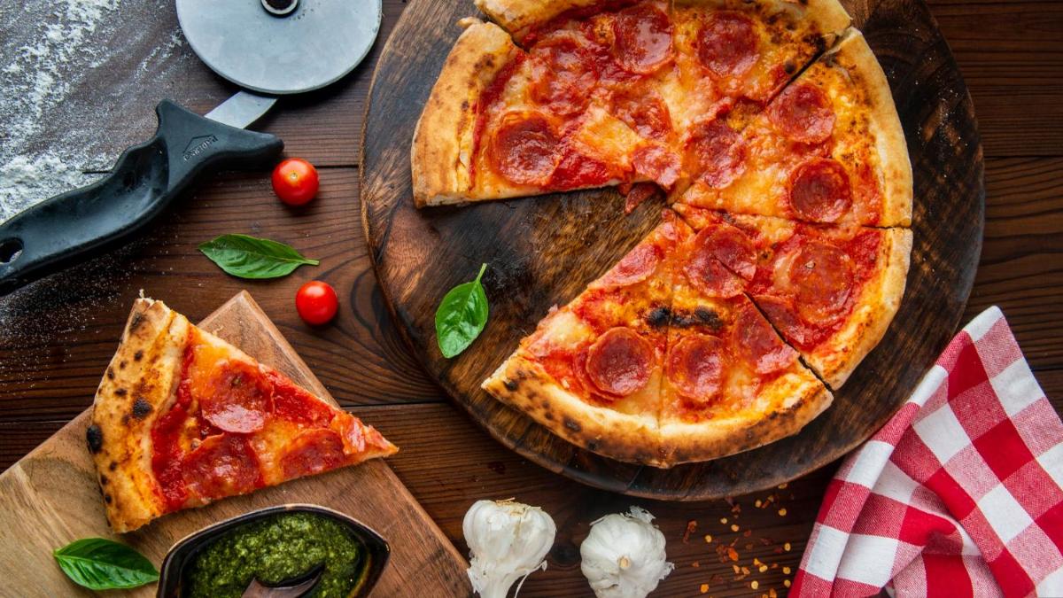 two slices of pizza on a wooden cutting board at Holiday Inn New Delhi Aerocity by IHG in New Delhi