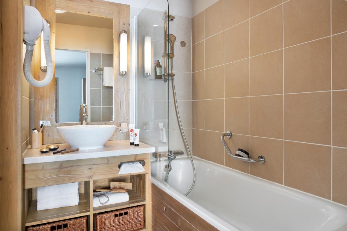 une salle de bain avec une baignoire et un lavabo dans l'établissement Résidence Pierre & Vacances Premium Les Terrasses d'Eos, à Flaine