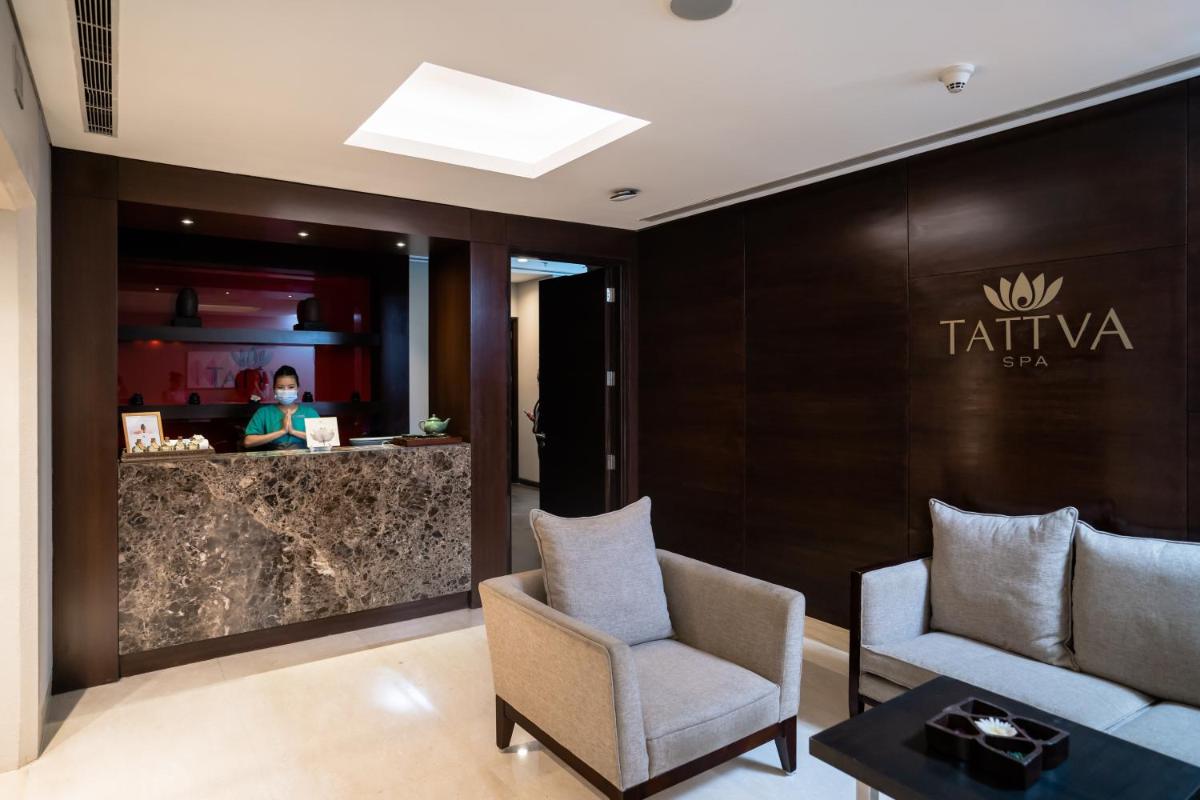 a woman sitting at a counter in a hotel lobby at Courtyard by Marriott Pune Hinjewadi in Pune