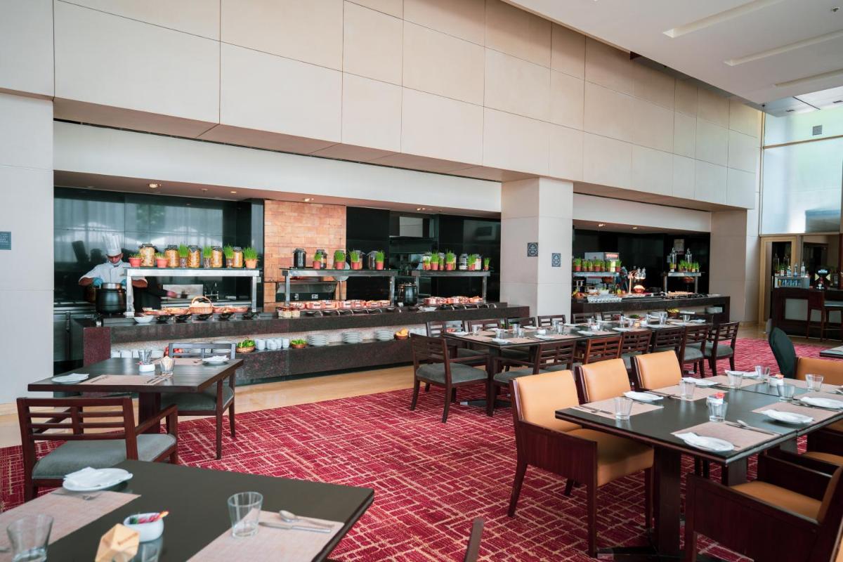a restaurant with tables and chairs and a bar at Courtyard by Marriott Pune Hinjewadi in Pune