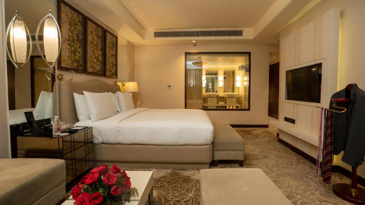 a hotel room with a bed and a living room at DoubleTree by Hilton Agra in Agra