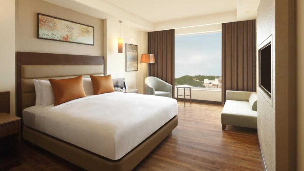 a hotel room with a bed and a large window at DoubleTree by Hilton Agra in Agra