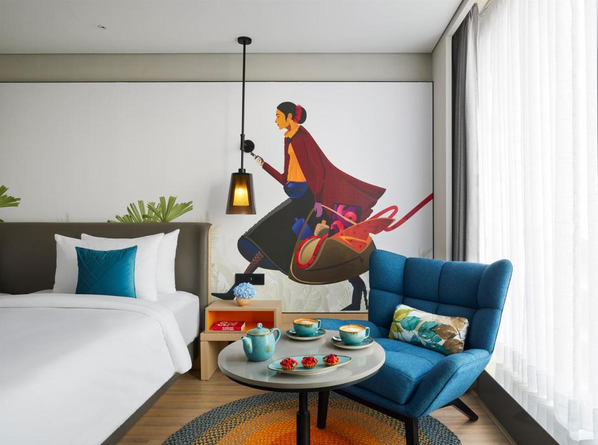 a bedroom with a bed and a blue chair at Hyatt Centric Hebbal Bengaluru in Bengaluru