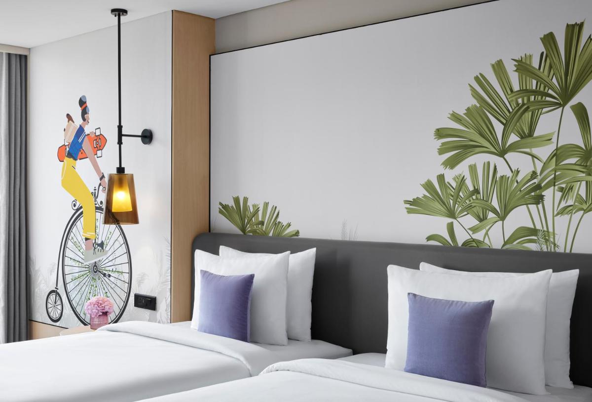 a bedroom with two beds with purple pillows at Hyatt Centric Hebbal Bengaluru in Bengaluru