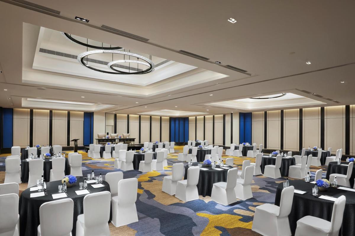a banquet hall with white chairs and tables in a room at Hyatt Centric Hebbal Bengaluru in Bengaluru