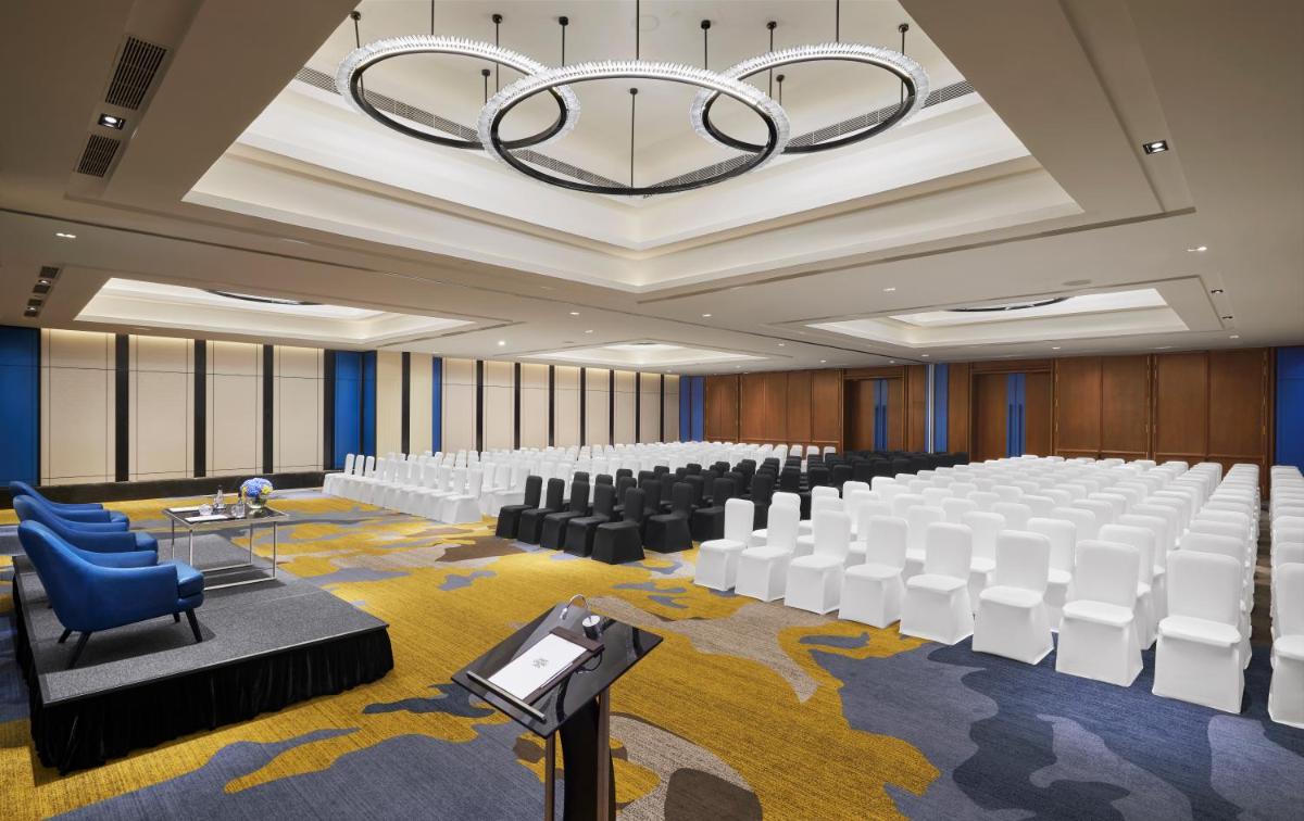a conference room with white chairs and a chandelier at Hyatt Centric Hebbal Bengaluru in Bengaluru
