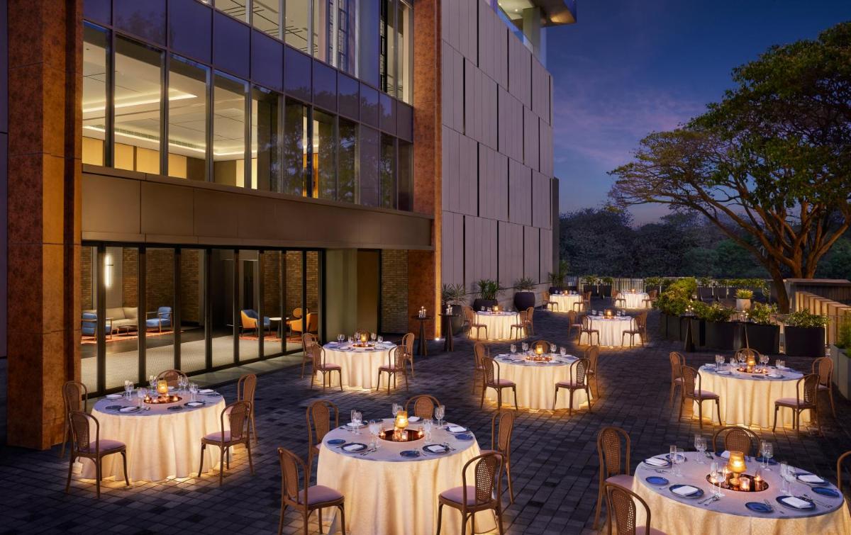 a group of tables in front of a building at Hyatt Centric Hebbal Bengaluru in Bengaluru