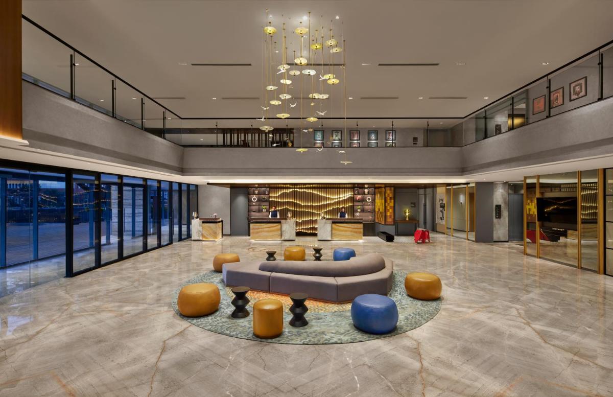 a lobby of a hotel with a couch and chairs at Hyatt Centric Hebbal Bengaluru in Bengaluru