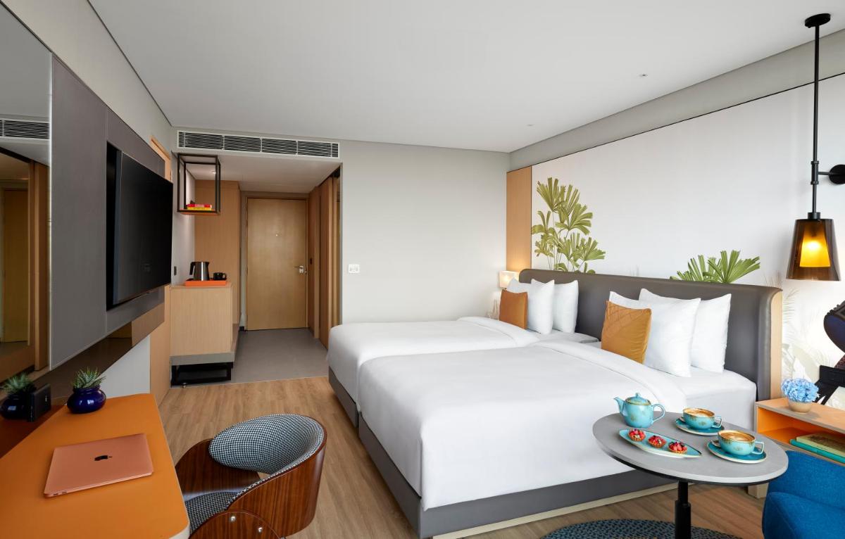 a bedroom with a large white bed and a table at Hyatt Centric Hebbal Bengaluru in Bengaluru