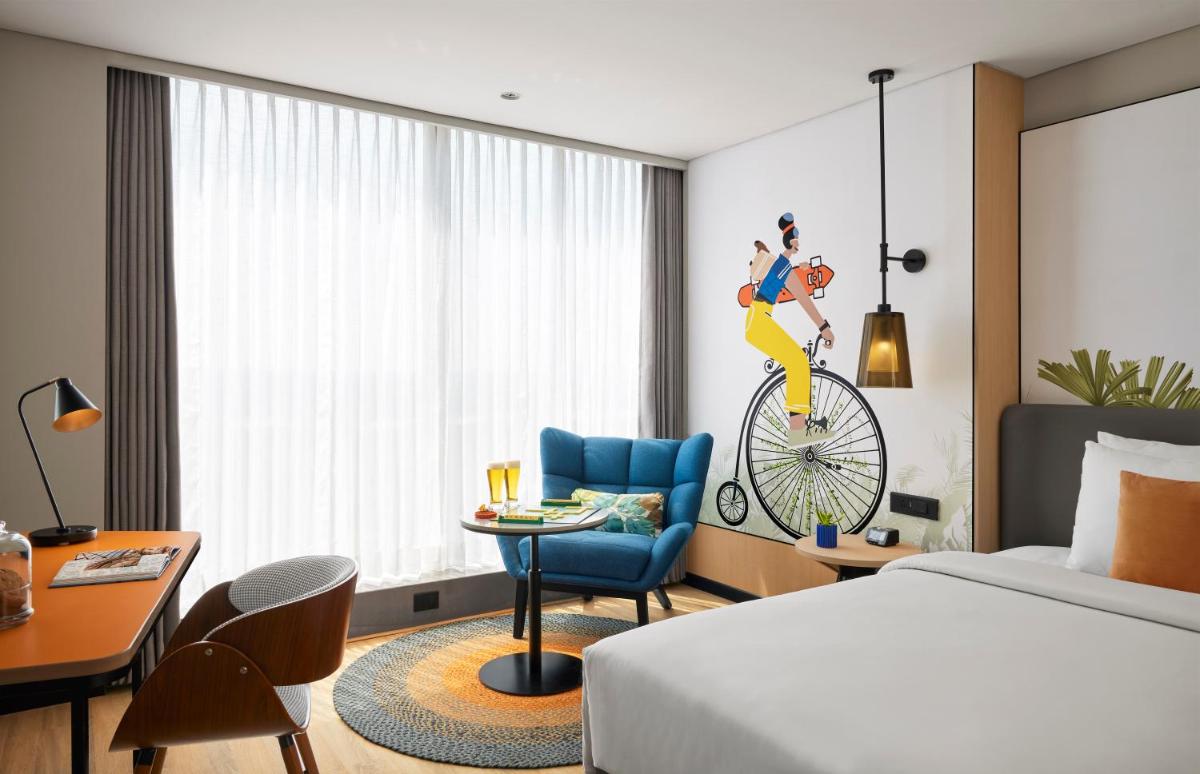 a hotel room with a bed and a desk and a chair at Hyatt Centric Hebbal Bengaluru in Bengaluru