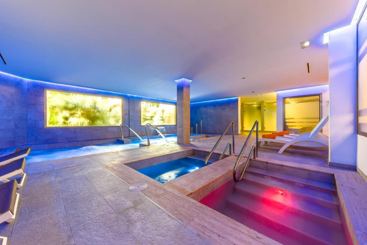 baño con bañera de hidromasaje en el centro en VIVA Cala Mesquida Resort & Spa, en Cala Mesquida