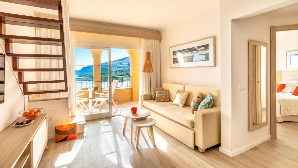 una sala de estar con un sofá y una mesa en VIVA Cala Mesquida Resort & Spa, en Cala Mesquida 154 fotos más