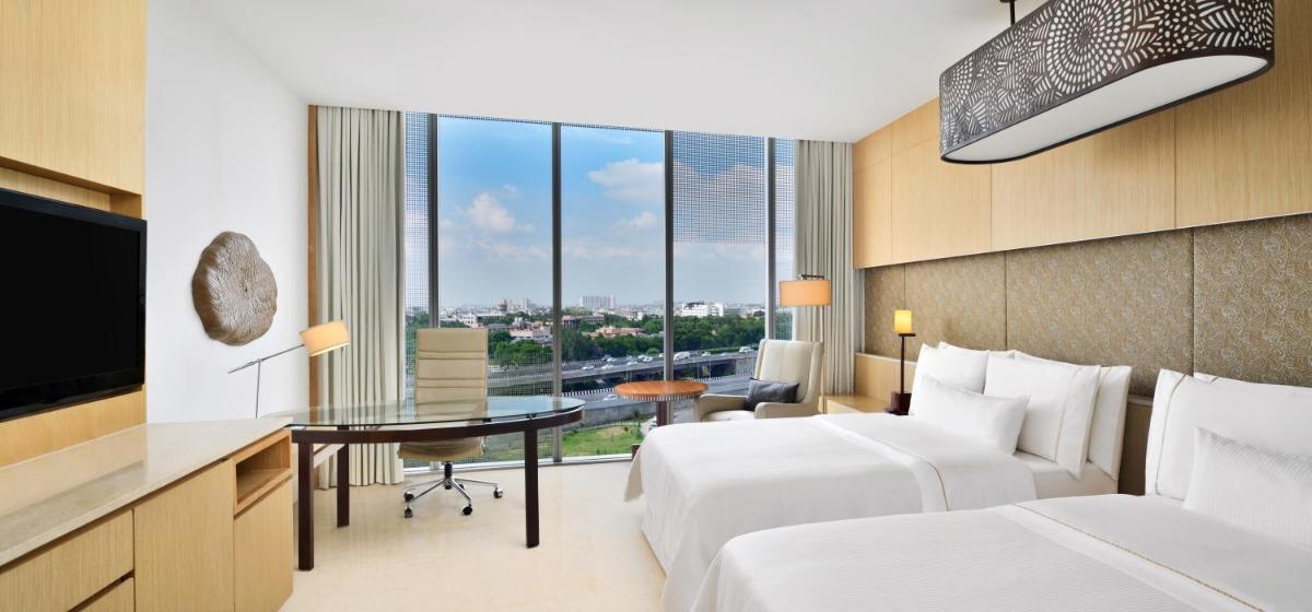 a hotel room with two beds and a desk at The Westin Gurgaon, New Delhi in Gurgaon