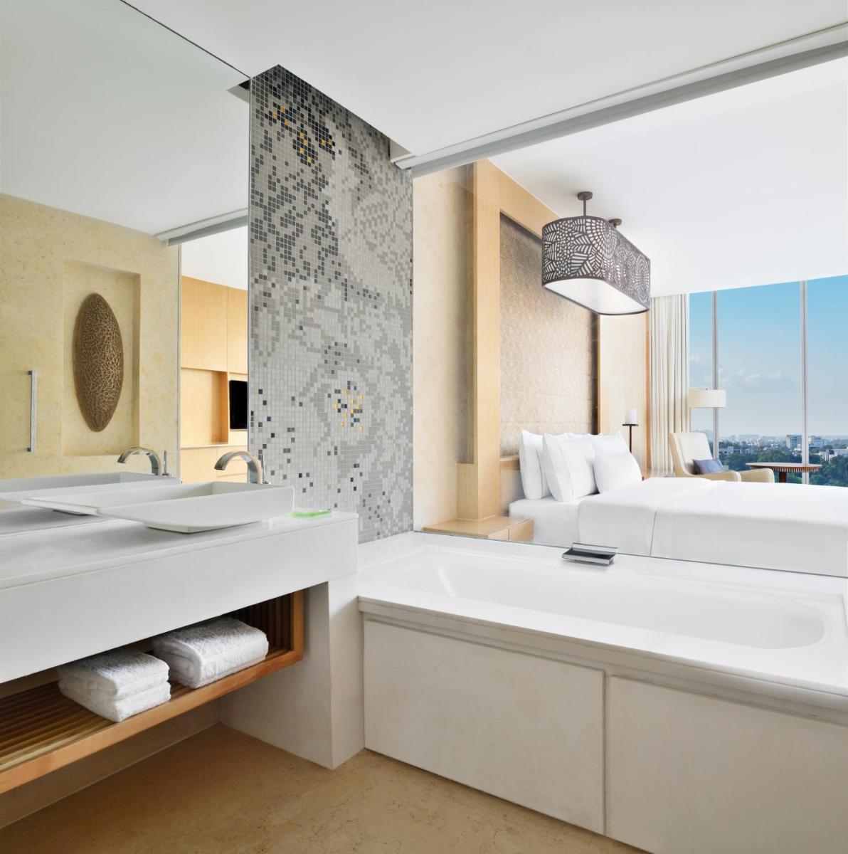 a bathroom with a tub and a sink and a bed at The Westin Gurgaon, New Delhi in Gurgaon