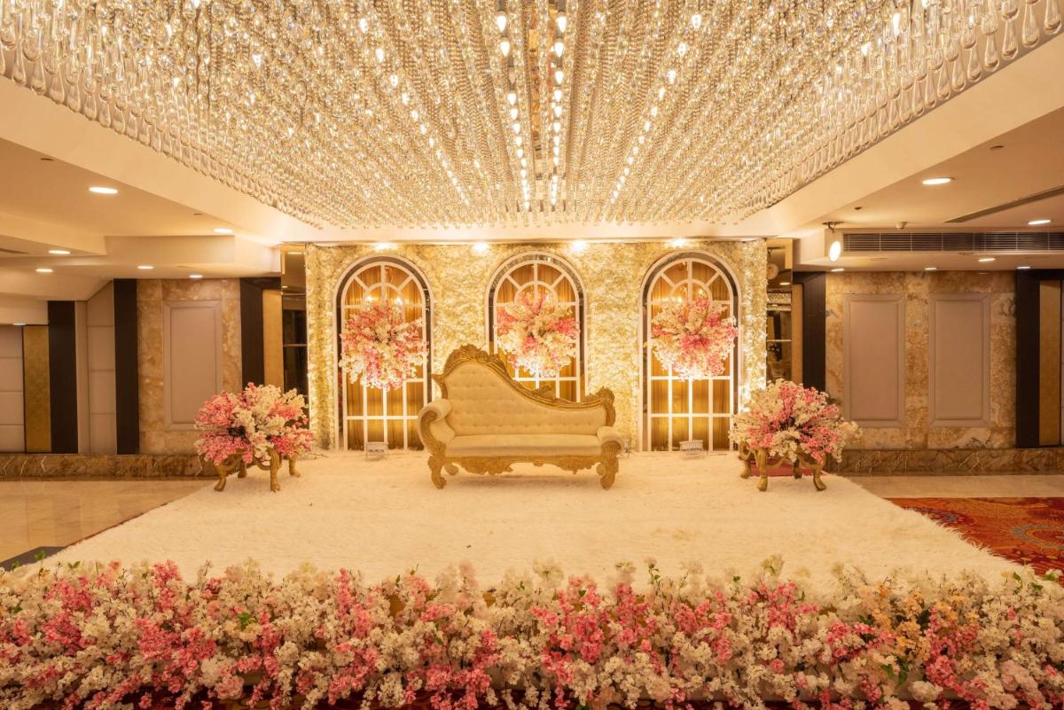 a living room with a couch on a stage with flowers at Radisson Blu Kaushambi Delhi NCR in Ghaziabad