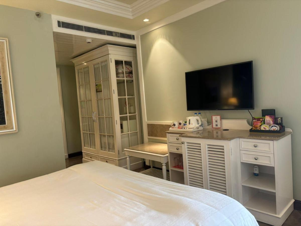 a bedroom with a bed and a desk with a television at Welcomhotel by ITC Hotels, The Savoy, Mussoorie in Mussoorie