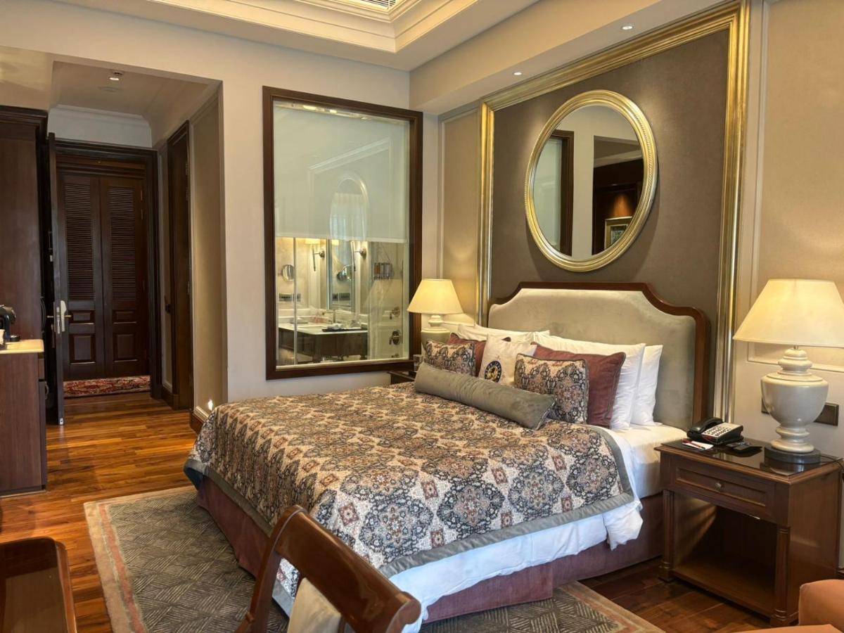 a bedroom with a large bed and a mirror at Welcomhotel by ITC Hotels, The Savoy, Mussoorie in Mussoorie