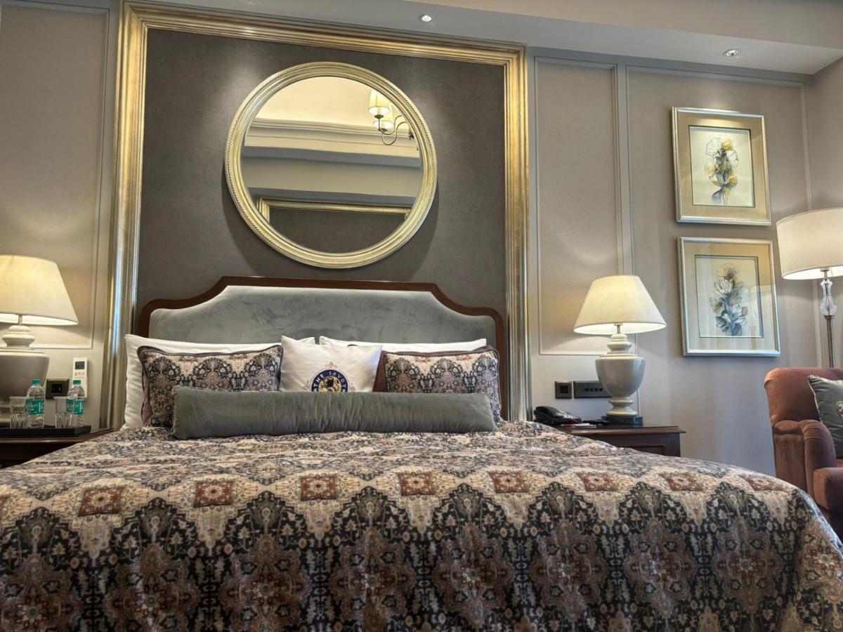 a bedroom with a large bed with a large mirror at Welcomhotel by ITC Hotels, The Savoy, Mussoorie in Mussoorie