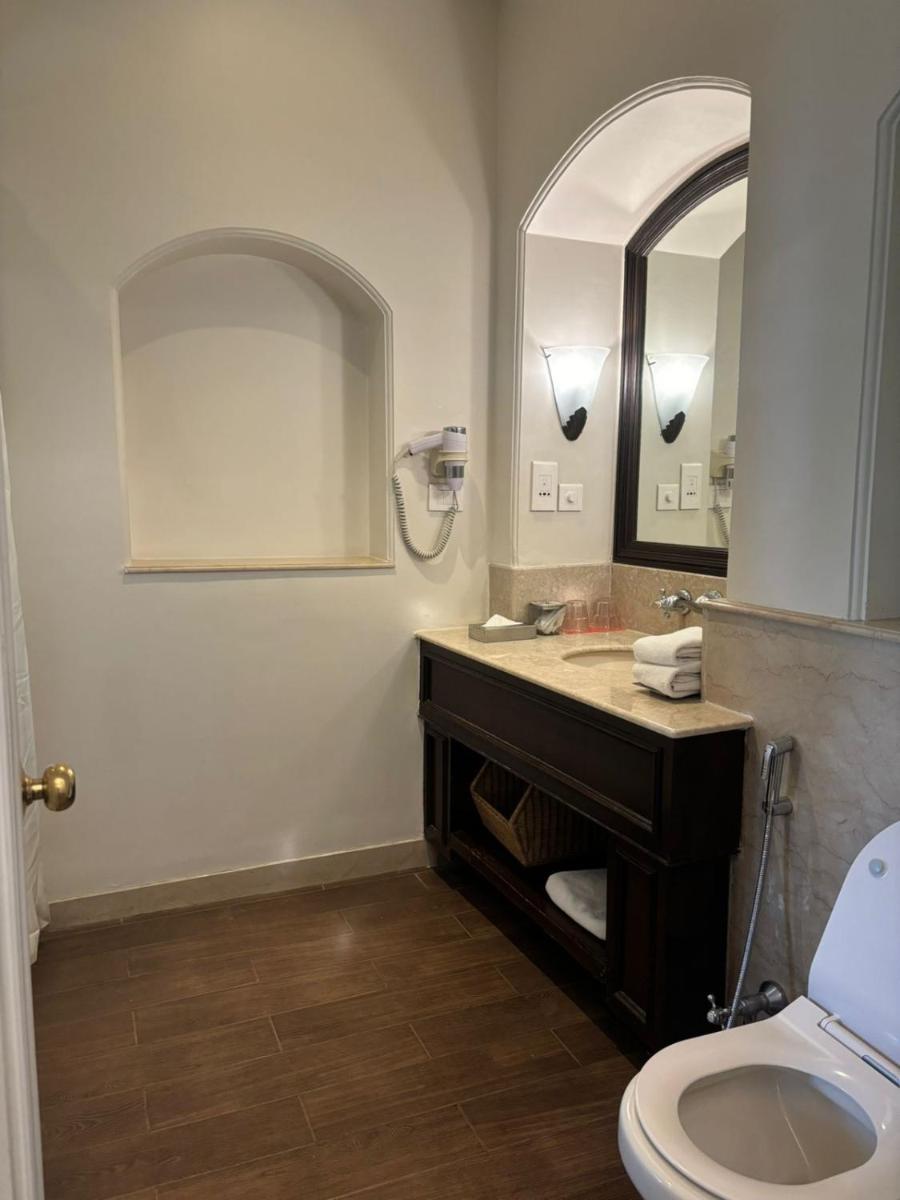 a bathroom with a sink and a mirror and a toilet at Welcomhotel by ITC Hotels, The Savoy, Mussoorie in Mussoorie