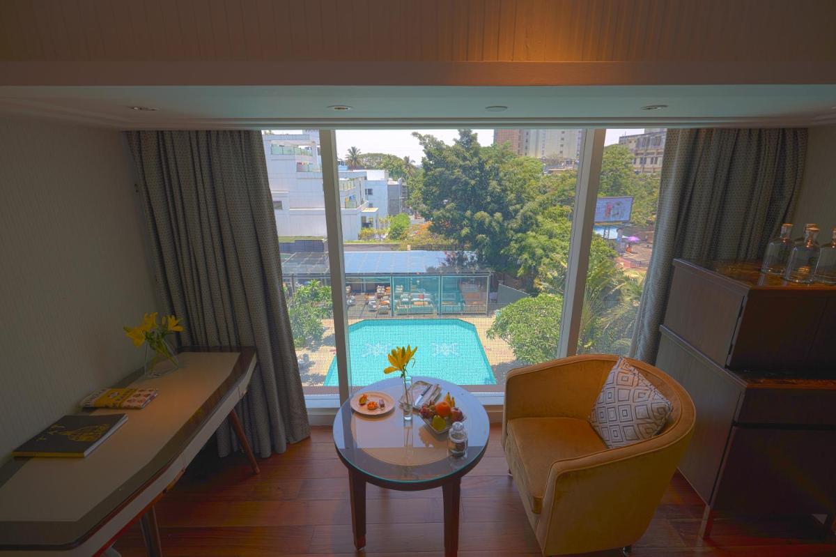 a living room with a table and a view of a pool at Taj MG Road Bengaluru in Bengaluru a living room with a table and a view of a pool at Taj MG Road Bengaluru in Bengaluru