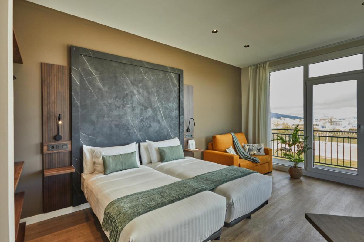 Un dormitorio con una cama grande y una ventana grande. en Apartamentos Silken Fontibre Iberia & Spa, en Nestares