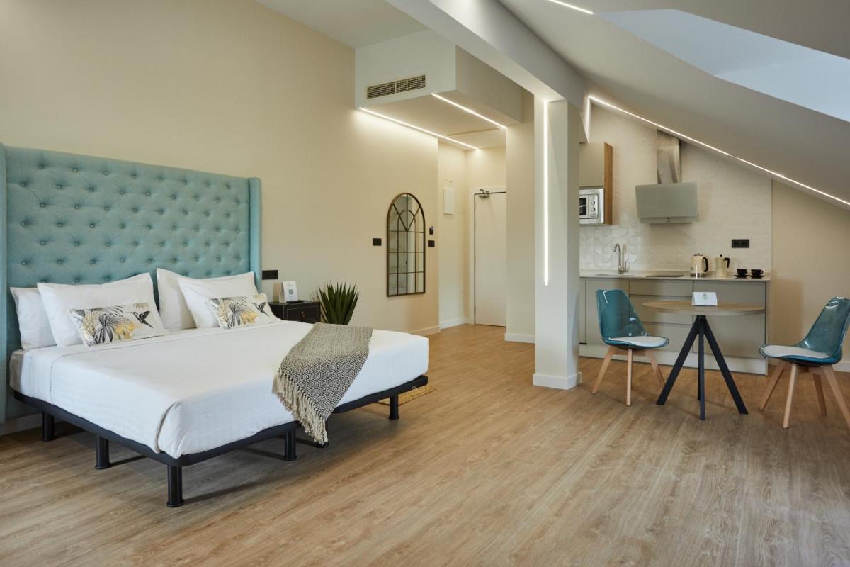 Un dormitorio con una cama grande y una cocina. en Apartamentos Silken Fontibre Iberia & Spa, en Nestares