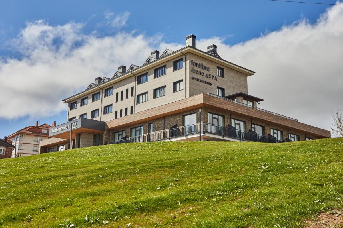 un edificio en la cima de una colina verde en Apartamentos Silken Fontibre Iberia & Spa, en Nestares