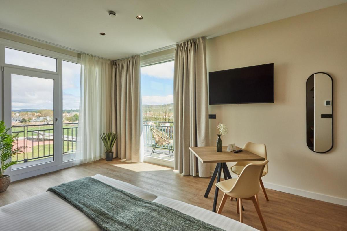 Un dormitorio con una cama y una mesa con escritorio. en Apartamentos Silken Fontibre Iberia & Spa, en Nestares