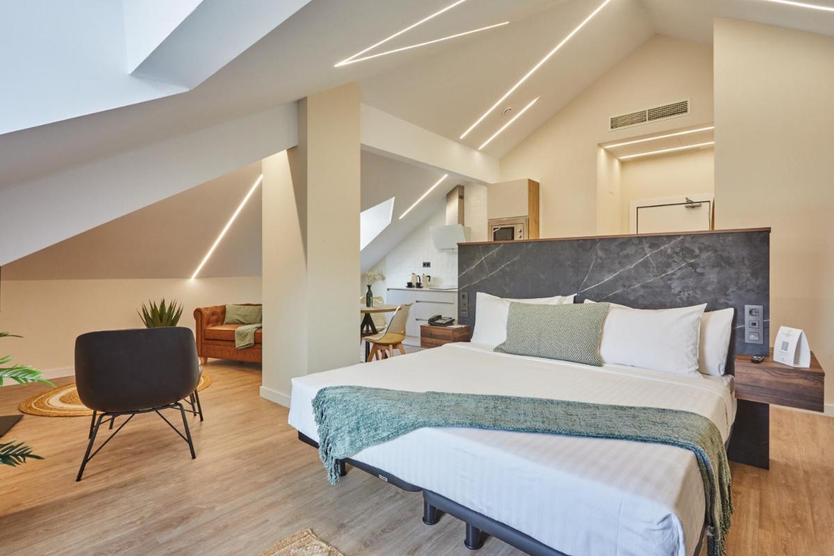 Un dormitorio con una cama grande y una silla. en Apartamentos Silken Fontibre Iberia & Spa, en Nestares