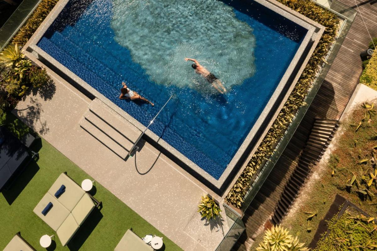 duas pessoas nadando em uma grande piscina em The Reserve - within Savoy Palace - The Leading Hotels of the World no Funchal