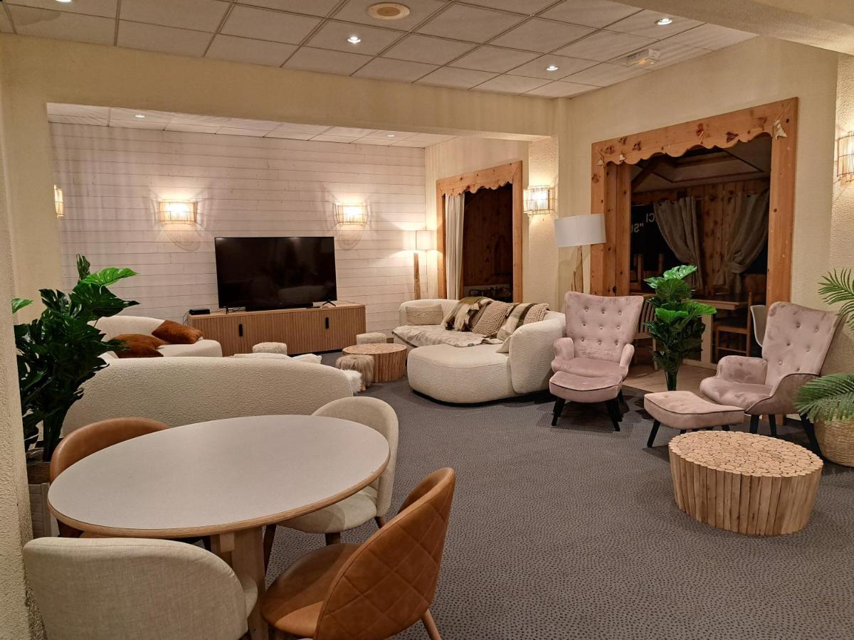 un salon avec des canapés, des fauteuils et une télévision dans l'établissement Hôtel Espace Montclar, à Montclar